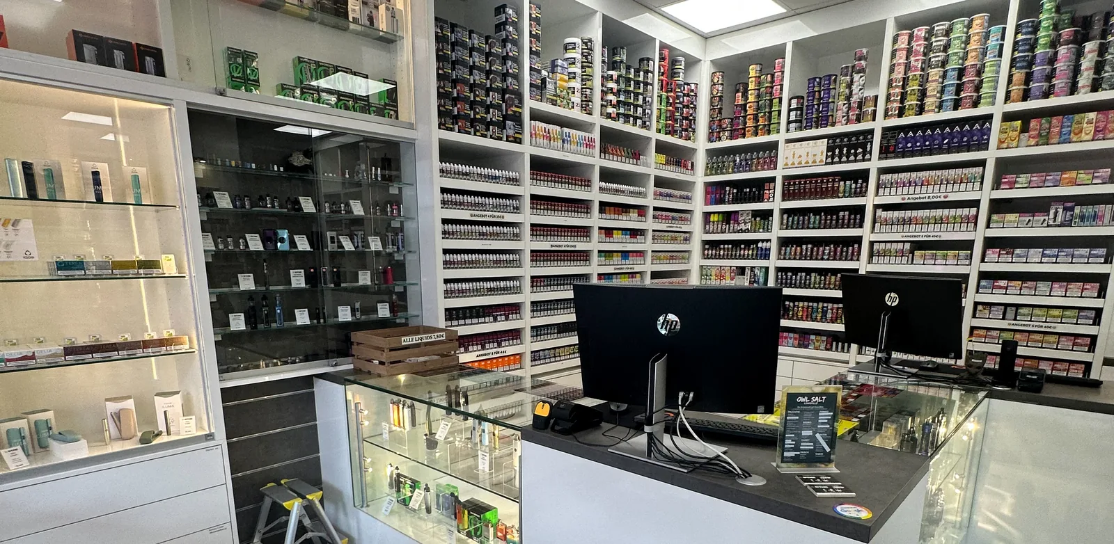 Regalwand mit Liquid-Flaschen sortiert nach Marke im ESMOKE-Laden